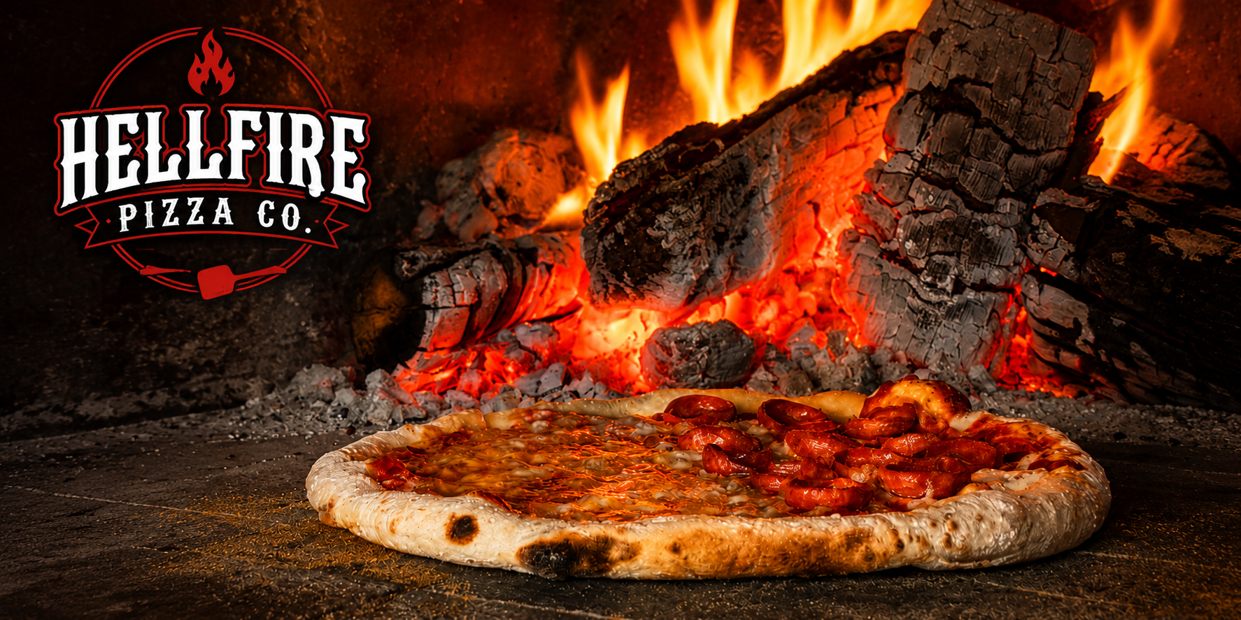 Hellfire Pizza Co wood-fired pizza in front of a blazing wood fire